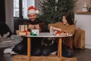 Couple wrapping Christmas gifts at home